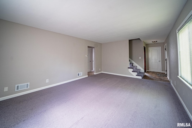 304 Meyers St, South Pekin, IL 61564 - unfurnished living room featuring dark colored carpet, stairs, baseboards, and plenty of natural light