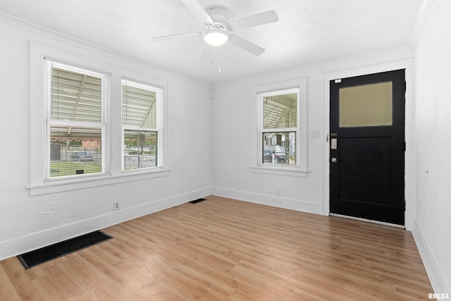 entryway with plenty of natural light, ornamental molding, light wood-style flooring, baseboards, and a ceiling fan