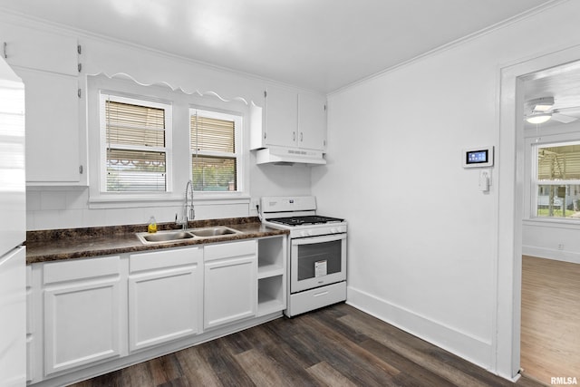 kitchen with white gas stove, a sink, under cabinet range hood, dark countertops, and dark wood-style flooring