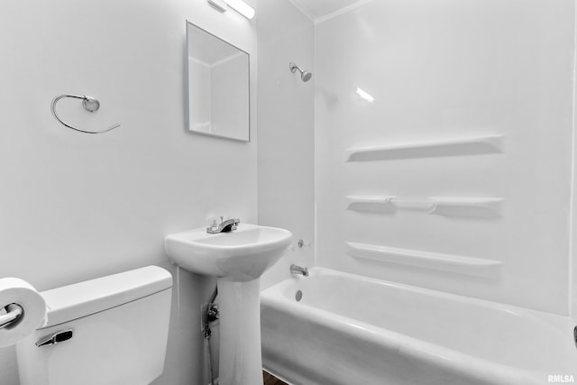 bathroom featuring toilet, washtub / shower combination, and a sink