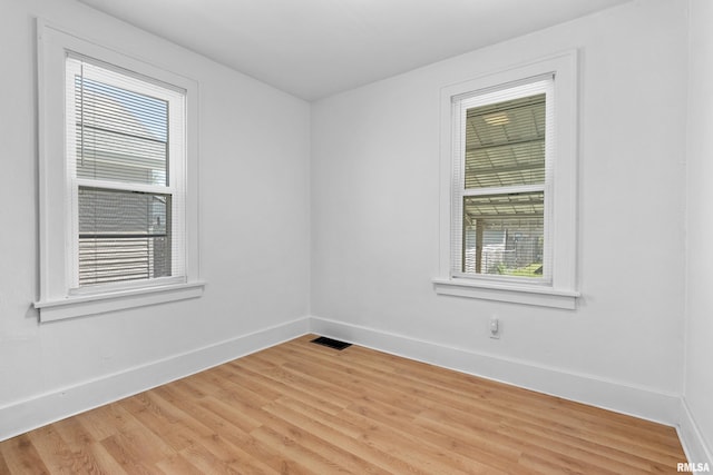 spare room with baseboards and light wood-style flooring