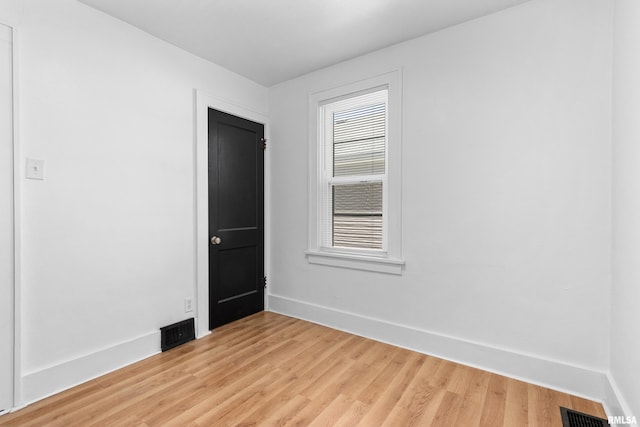 empty room with baseboards and light wood finished floors