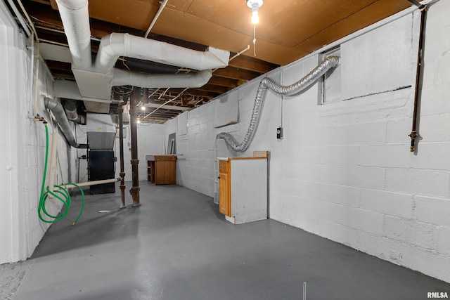 unfinished basement with concrete block wall and heating unit