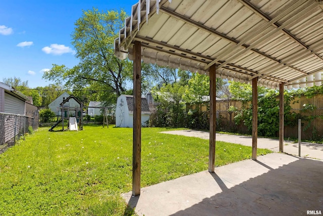 view of yard featuring a patio area, a shed, and an outbuilding