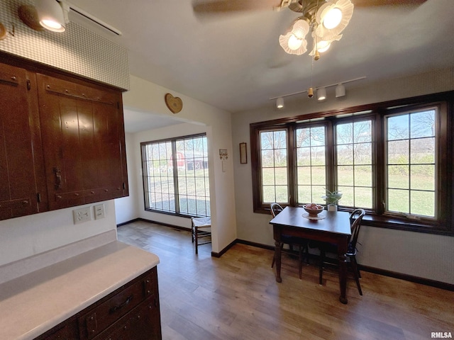 dining area featuring light wood-type flooring, baseboards, and rail lighting