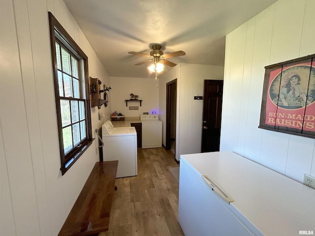 clothes washing area with independent washer and dryer, light wood-type flooring, and a ceiling fan