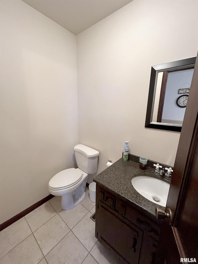 bathroom featuring toilet, vanity, tile patterned flooring, and baseboards