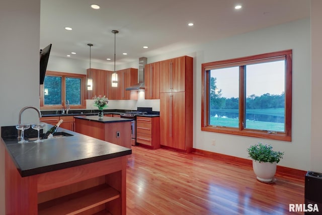 6 Marty Ln, Macomb, IL 61455 - kitchen with stainless steel range with gas stovetop, dark countertops, wall chimney exhaust hood, a kitchen island, and light wood-type flooring