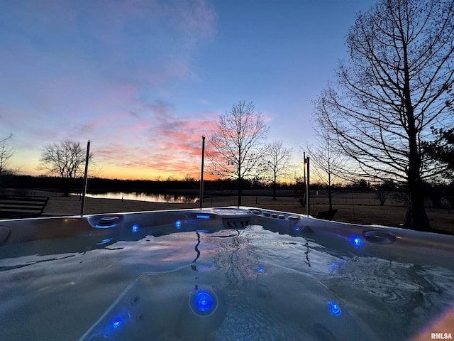 6 Marty Ln, Macomb, IL 61455 - pool at dusk with a hot tub, fence, and a water view