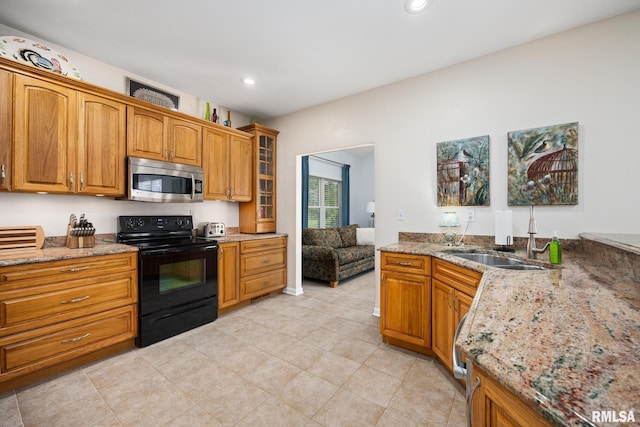 kitchen with stainless steel microwave, black / electric stove, a sink, light stone counters, and recessed lighting