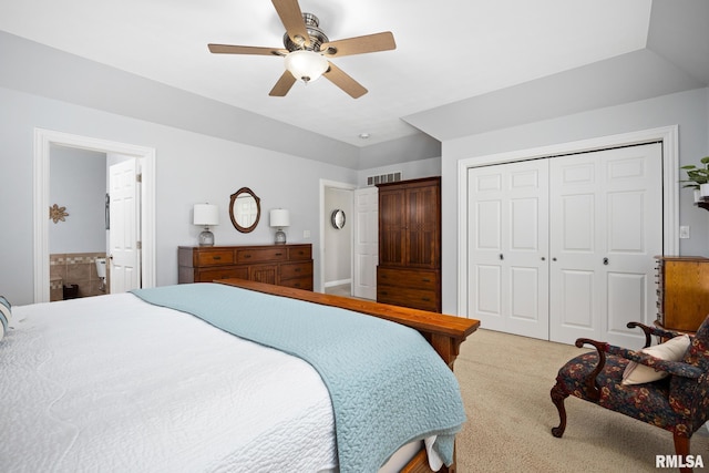 bedroom with light carpet, a closet, a ceiling fan, and ensuite bathroom