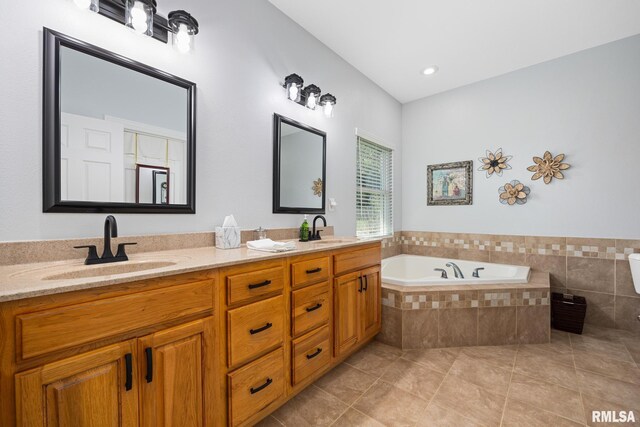 full bathroom with tile patterned flooring, a bath, and double vanity