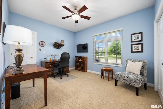 carpeted home office with ceiling fan and baseboards