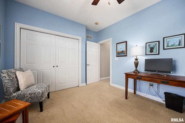 home office featuring light colored carpet, a ceiling fan, and baseboards