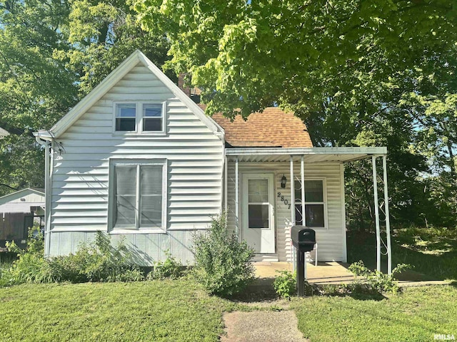 bungalow with covered porch and a front yard