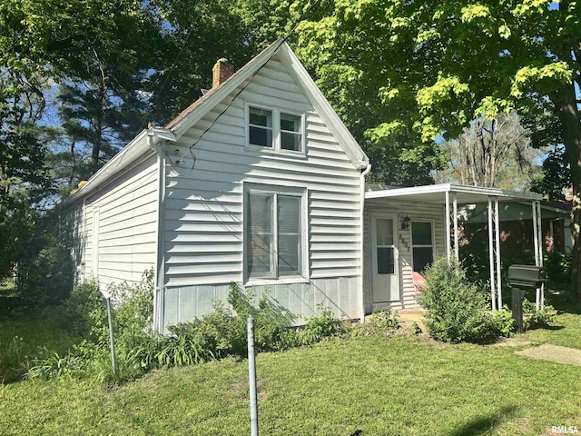 view of front facade featuring a front lawn and a chimney