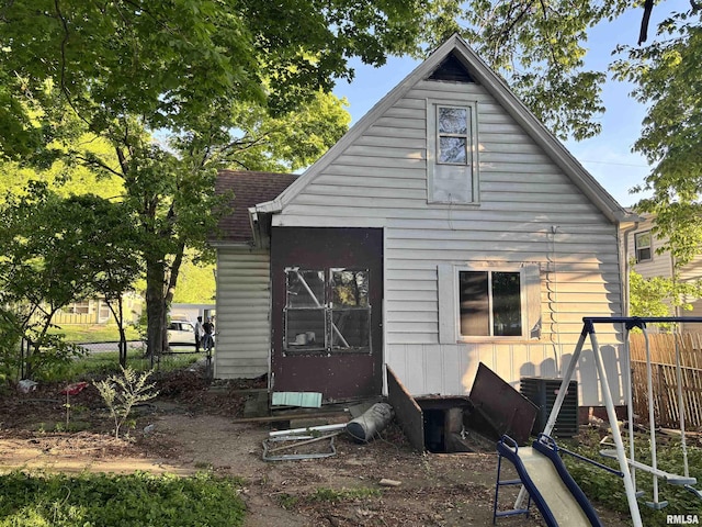 rear view of house with fence, entry steps, and central air condition unit