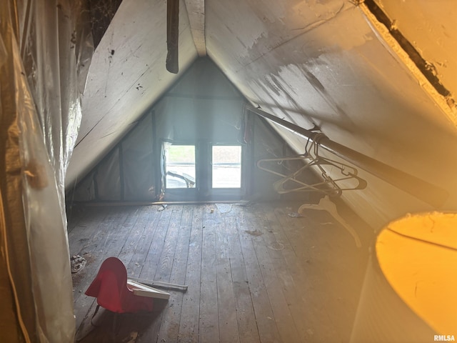 additional living space with hardwood / wood-style flooring and vaulted ceiling