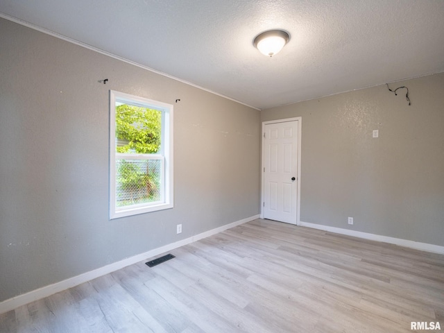246 Herget St, Pekin, IL 61554 - spare room featuring light wood-style flooring, baseboards, a textured ceiling, and ornamental molding