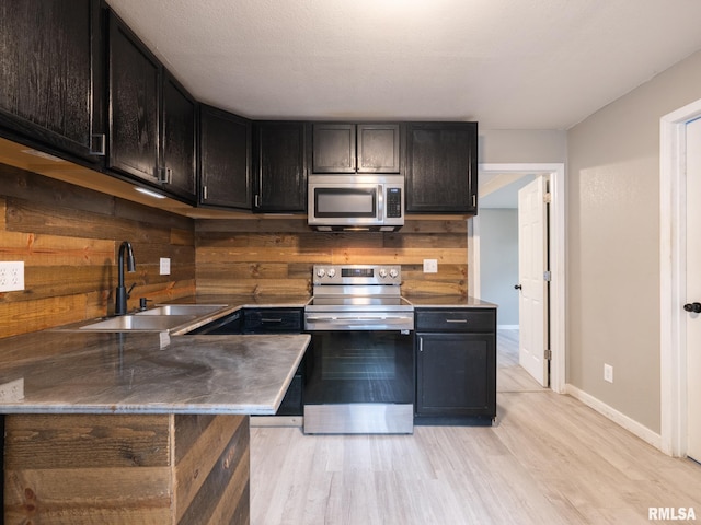 246 Herget St, Pekin, IL 61554 - kitchen featuring stainless steel appliances, a sink, light wood-type flooring, and baseboards