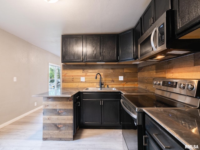 246 Herget St, Pekin, IL 61554 - kitchen with appliances with stainless steel finishes, a sink, light wood-type flooring, baseboards, and a peninsula