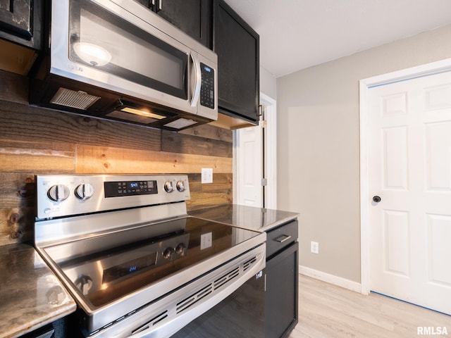 246 Herget St, Pekin, IL 61554 - kitchen featuring appliances with stainless steel finishes, dark cabinets, light wood-type flooring, and baseboards