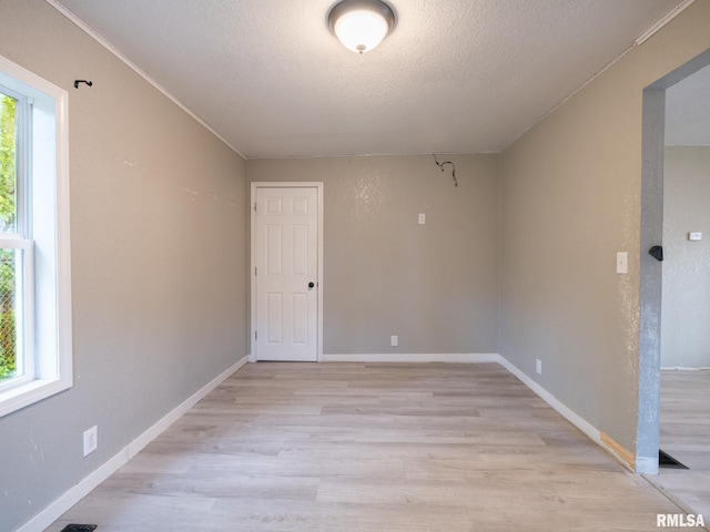 246 Herget St, Pekin, IL 61554 - empty room featuring light wood-style flooring, a textured ceiling, and baseboards