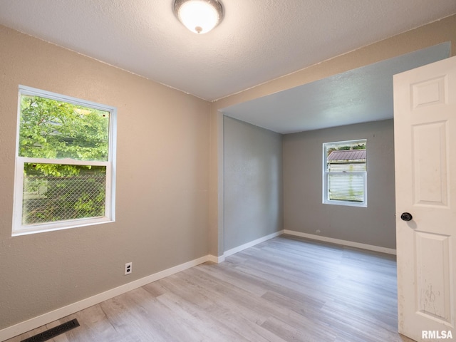 246 Herget St, Pekin, IL 61554 - empty room with light wood-type flooring, baseboards, and a textured ceiling