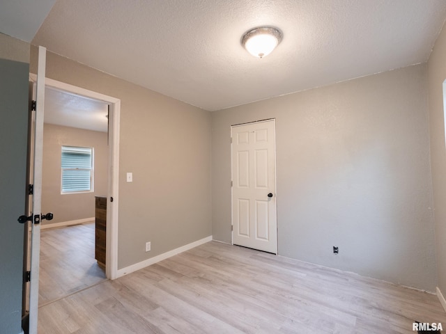 246 Herget St, Pekin, IL 61554 - spare room featuring light wood finished floors, a textured ceiling, and baseboards