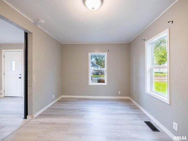 246 Herget St, Pekin, IL 61554 - unfurnished room with healthy amount of natural light, light wood finished floors, crown molding, and a textured ceiling