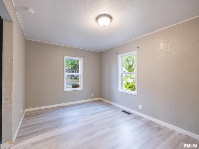 246 Herget St, Pekin, IL 61554 - empty room with a textured wall, a textured ceiling, light wood-style floors, crown molding, and a smoke detector