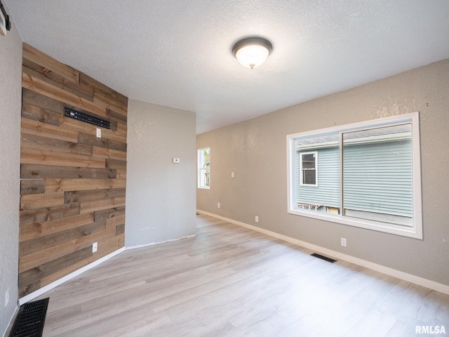246 Herget St, Pekin, IL 61554 - empty room featuring wood finished floors, wood walls, a textured ceiling, and baseboards