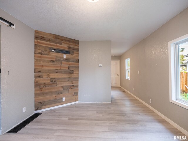 246 Herget St, Pekin, IL 61554 - empty room with wood finished floors, wood walls, a barn door, and baseboards