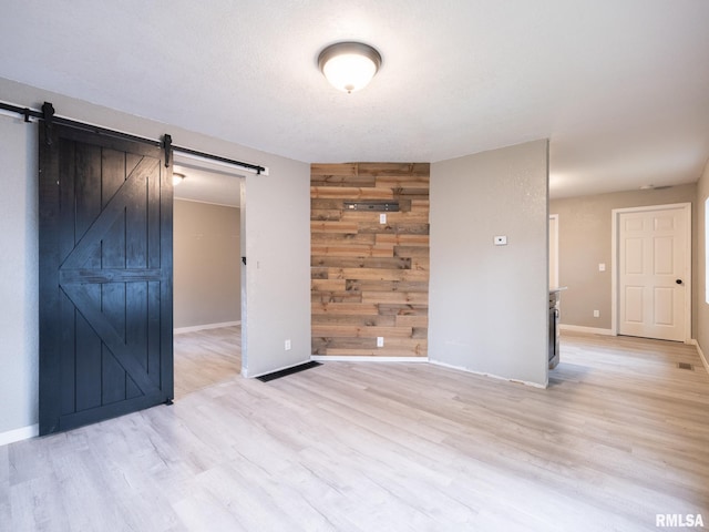 246 Herget St, Pekin, IL 61554 - unfurnished room with a barn door, light wood finished floors, and baseboards