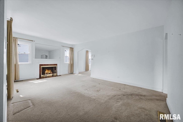 2309 W Manor Pkwy, West Peoria, IL 61604 - unfurnished living room with carpet floors, a fireplace, baseboards, and arched walkways