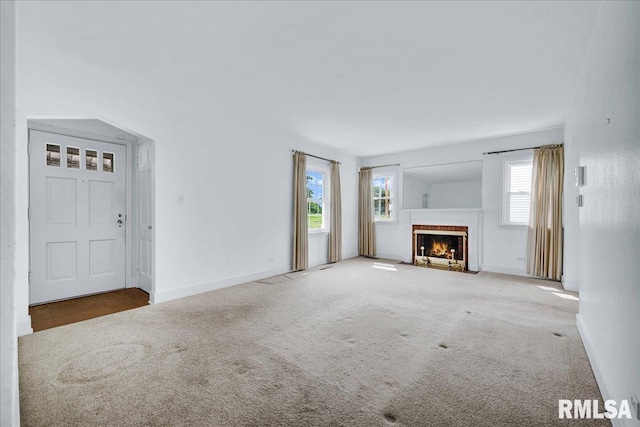 2309 W Manor Pkwy, West Peoria, IL 61604 - unfurnished living room with carpet, healthy amount of natural light, a fireplace with flush hearth, and baseboards