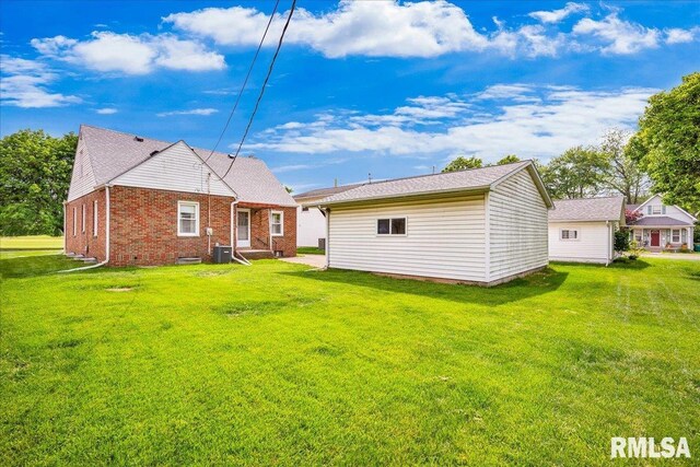 2309 W Manor Pkwy, West Peoria, IL 61604 - rear view of house with a lawn, central AC unit, and brick siding