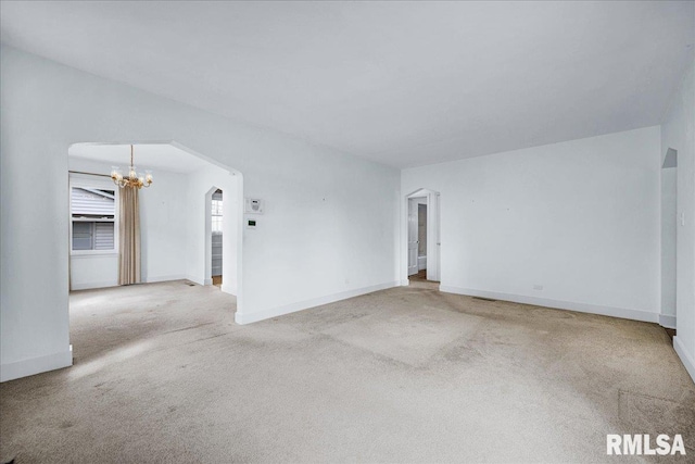 2309 W Manor Pkwy, West Peoria, IL 61604 - carpeted spare room with arched walkways, a chandelier, and baseboards