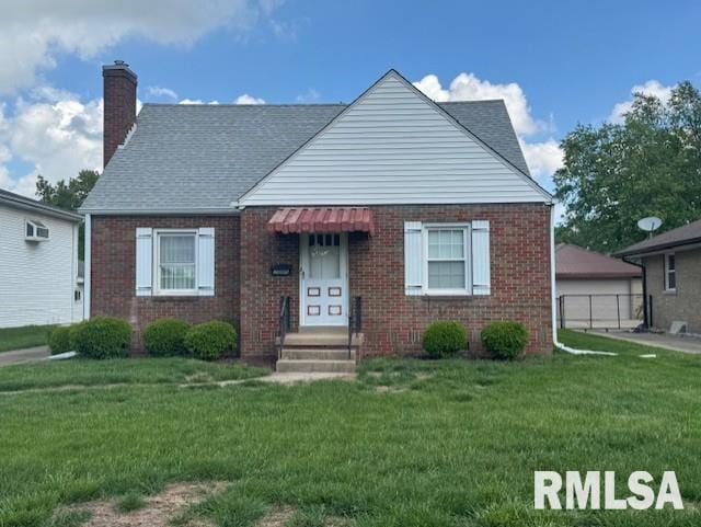 2309 W Manor Pkwy, West Peoria, IL 61604 - bungalow-style home with brick siding, a chimney, a front yard, and a garage