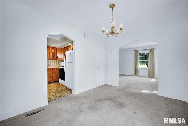 2309 W Manor Pkwy, West Peoria, IL 61604 - unfurnished room featuring arched walkways, a chandelier, light colored carpet, and baseboards