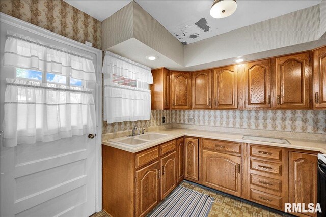 2309 W Manor Pkwy, West Peoria, IL 61604 - kitchen featuring a sink, brown cabinets, wallpapered walls, light countertops, and electric range oven