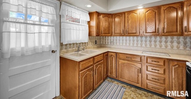 2309 W Manor Pkwy, West Peoria, IL 61604 - kitchen with brown cabinetry, a sink, light countertops, range with electric stovetop, and recessed lighting
