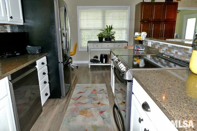 kitchen with stainless steel range with electric cooktop, tasteful backsplash, light wood-style floors, dark stone countertops, and white cabinetry