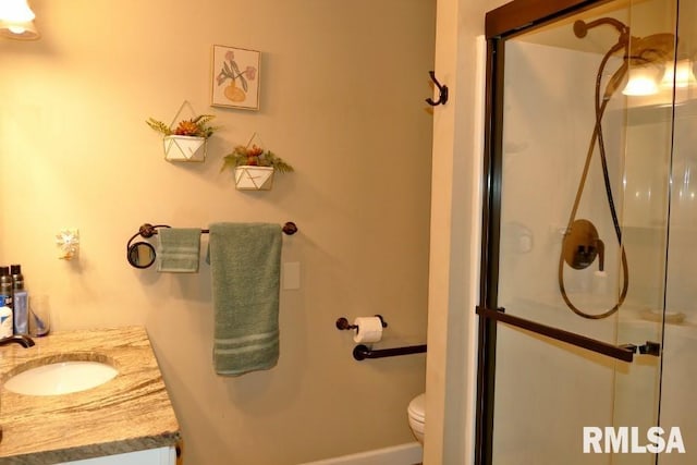 full bathroom featuring a shower stall, vanity, toilet, and baseboards
