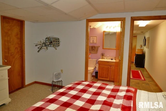bedroom featuring ensuite bath and a sink