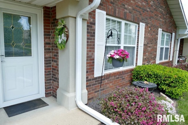 entrance to property featuring brick siding
