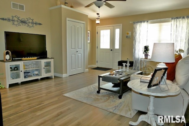 living area featuring a ceiling fan, wood finished floors, and baseboards