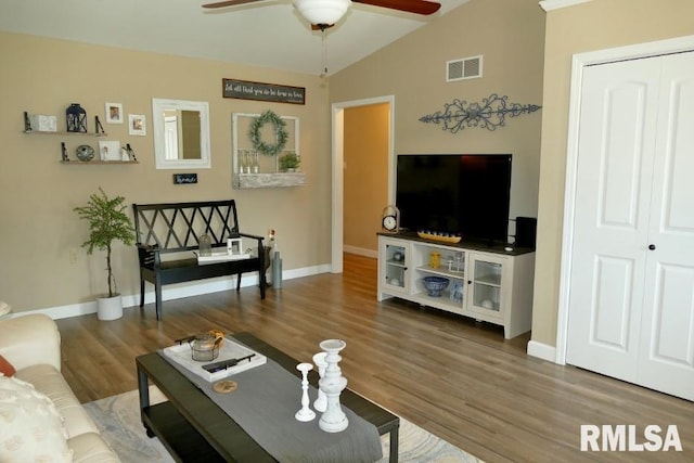 living area with a ceiling fan, wood finished floors, baseboards, and vaulted ceiling