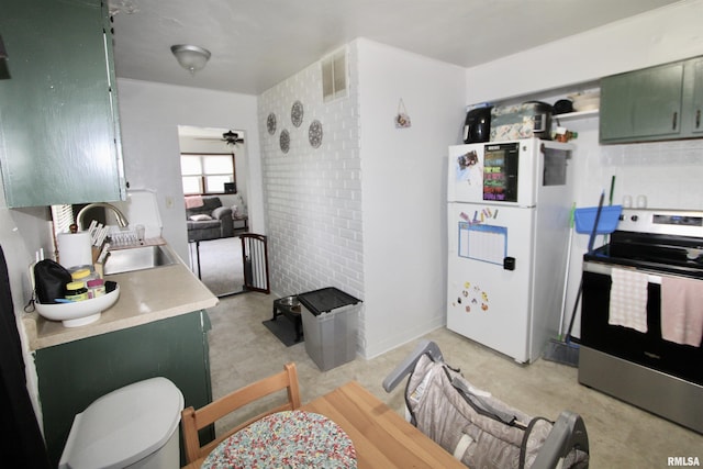 109 N 19th St, Pekin, IL 61554 - kitchen with green cabinetry, stainless steel range with electric cooktop, freestanding refrigerator, and a sink