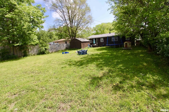 109 N 19th St, Pekin, IL 61554 - view of yard featuring a trampoline, a storage shed, and an outbuilding